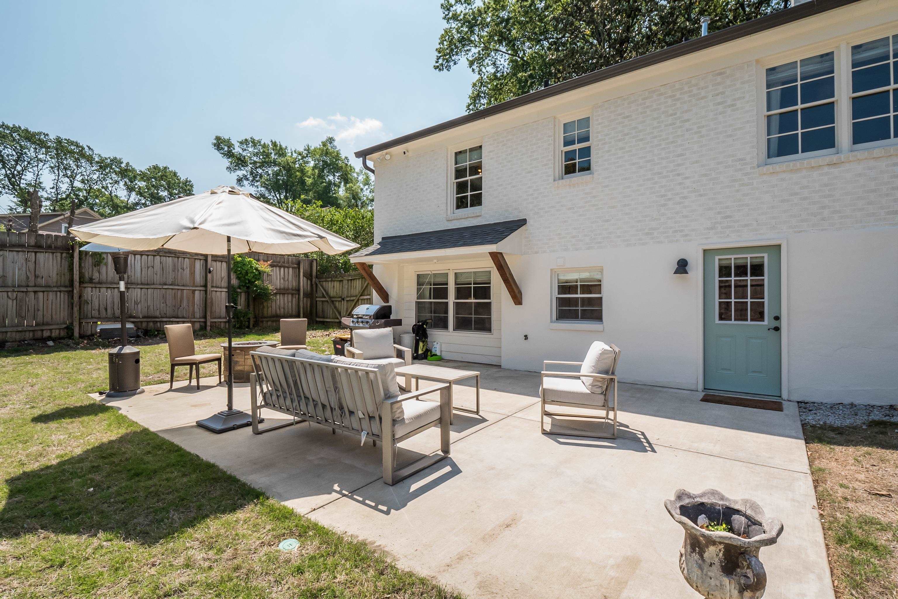 4800 Barfield Road Memphis, TN 38117 - Photo 22 of 25 a view of a patio with table and chairs under an umbrella with a fire pit