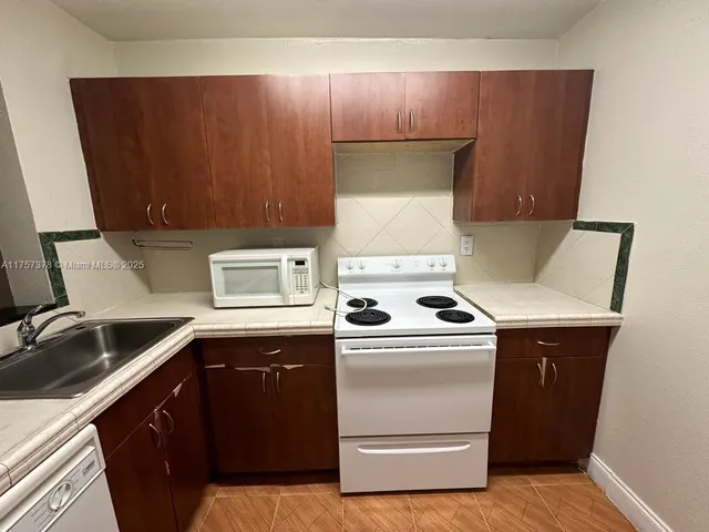 a kitchen with a refrigerator sink and cabinets