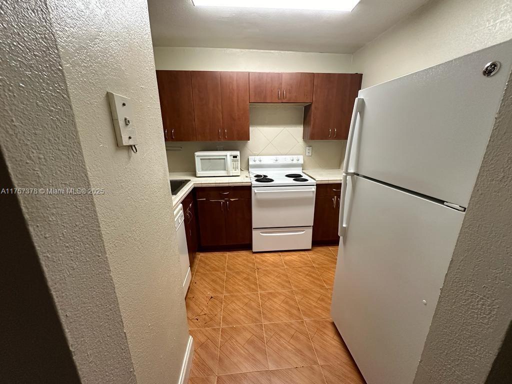 492 Northwest 165th Street, Unit C211 Miami, FL 33169 - Photo 16 of 26 a utility room with washer and dryer