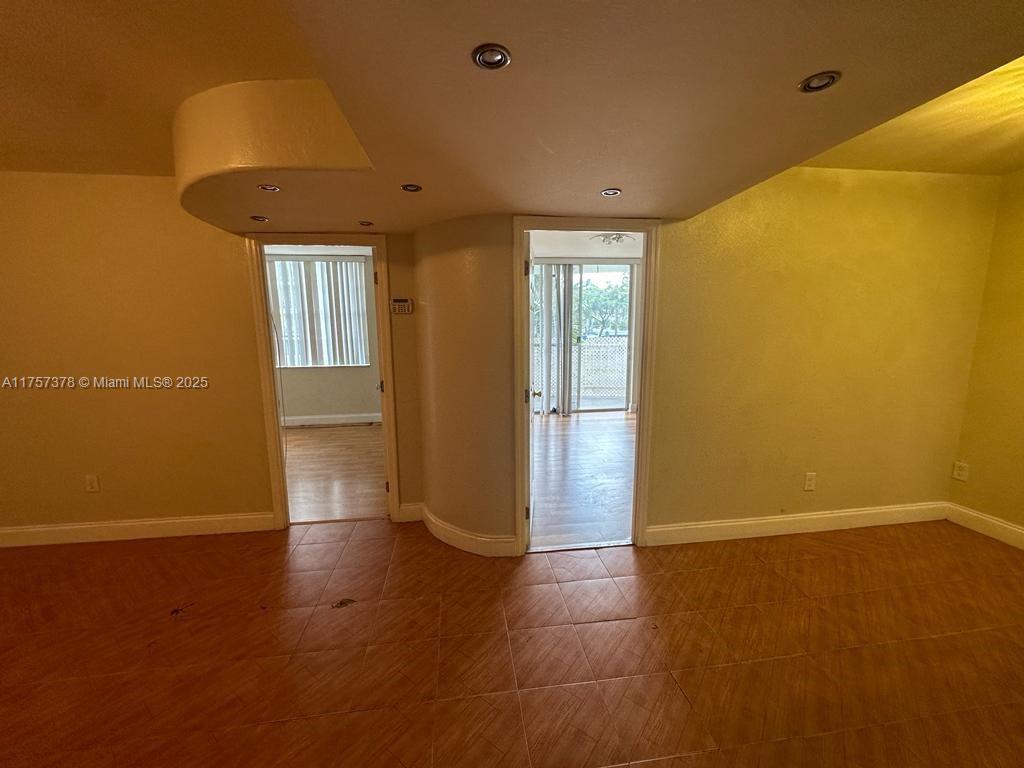 492 Northwest 165th Street, Unit C211 Miami, FL 33169 - Photo 19 of 26 an empty room with wooden floor and windows