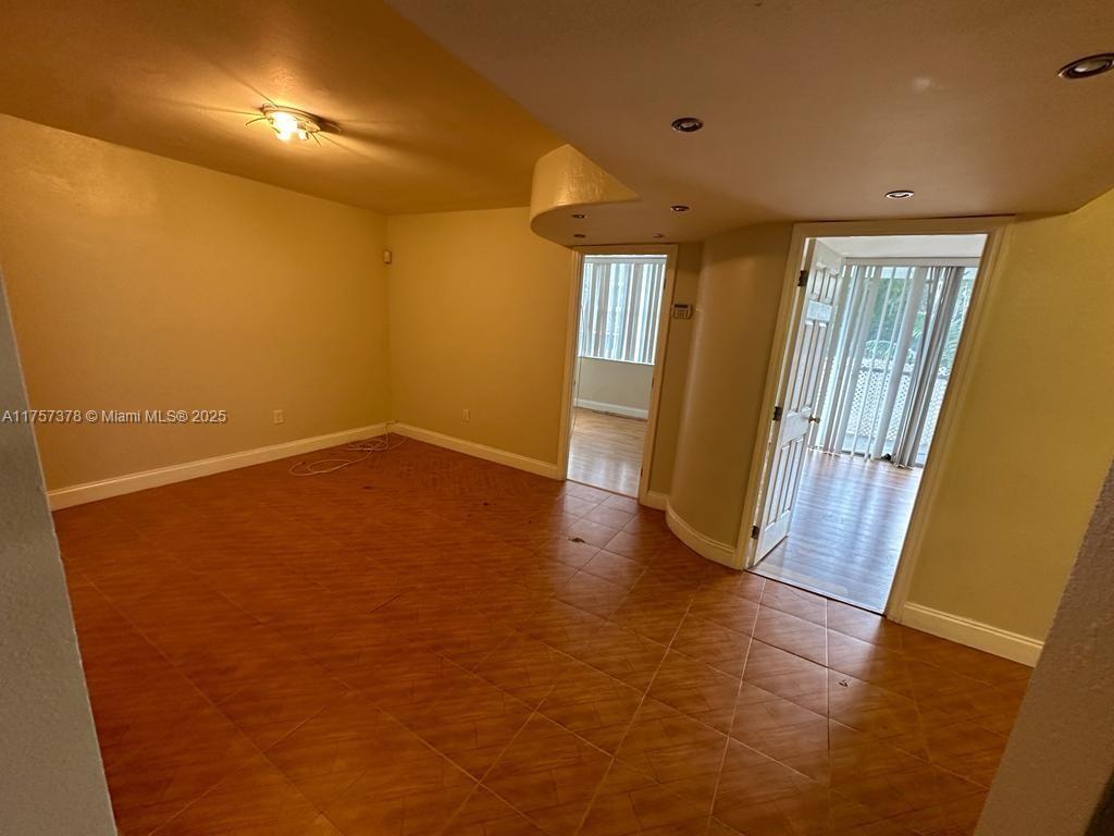 492 Northwest 165th Street, Unit C211 Miami, FL 33169 - Photo 21 of 26 a view of an empty room with wooden floor and a window