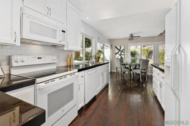 a kitchen with cabinets and wooden floor