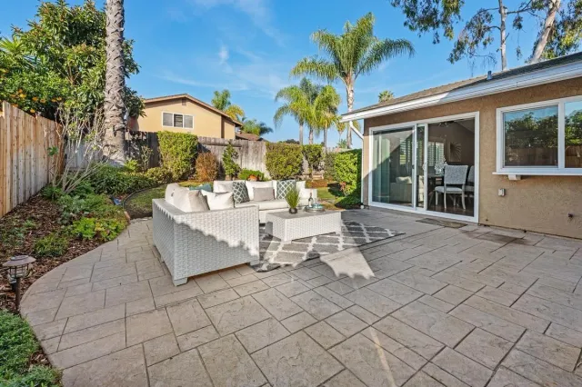 a view of a patio with couches table and chairs and potted plants