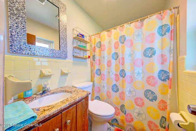 a bathroom with a sink toilet and shower curtain