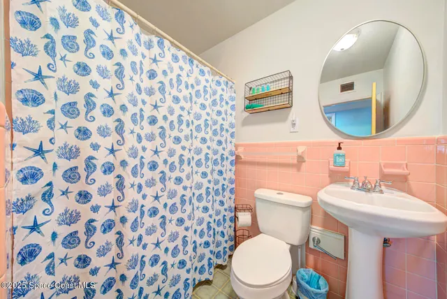 a bathroom with a toilet a sink and a mirror