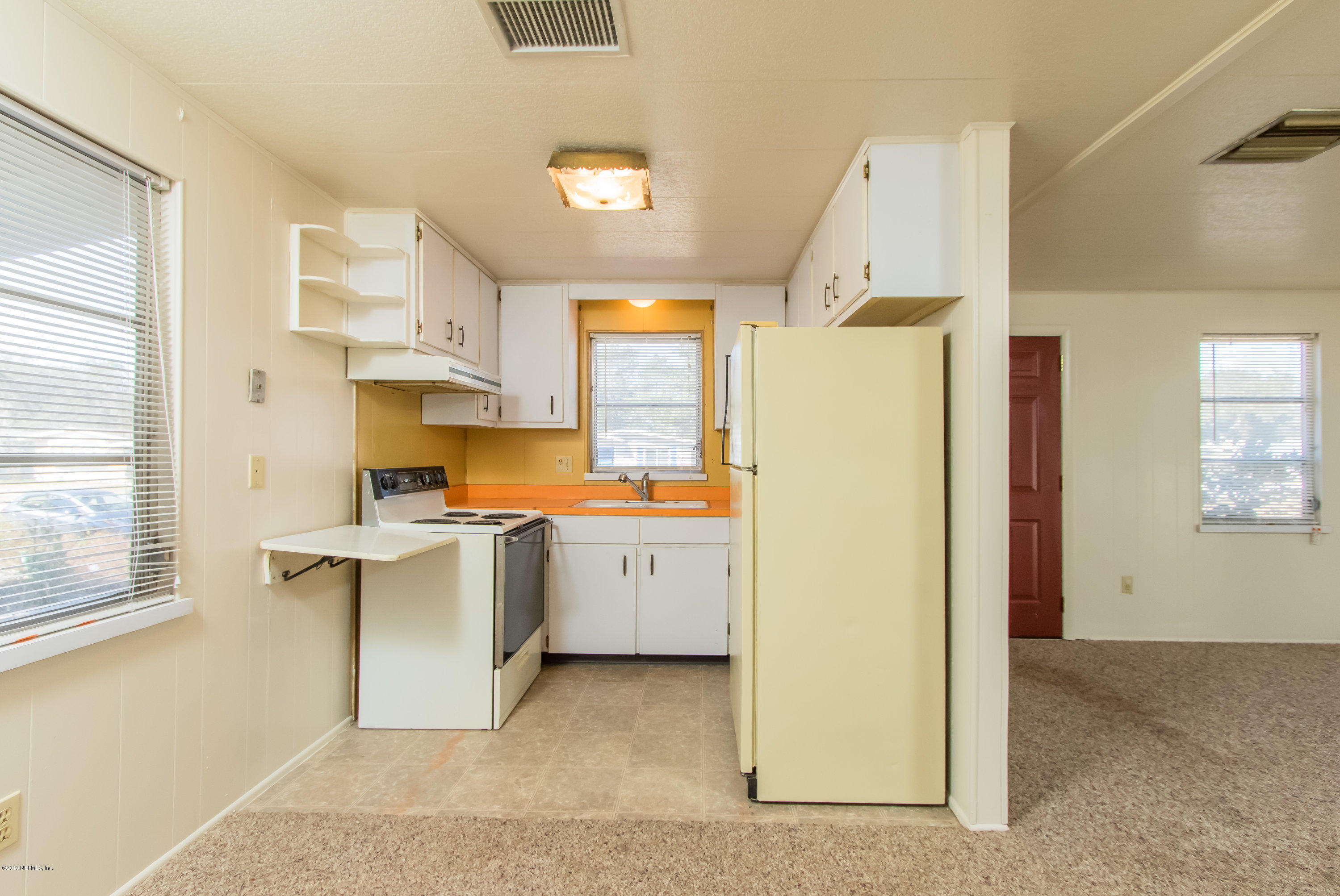 893 Palermo Road St. Augustine, FL 32086 - Photo 15 of 25 a kitchen with a refrigerator a sink dishwasher with a dining table and chairs