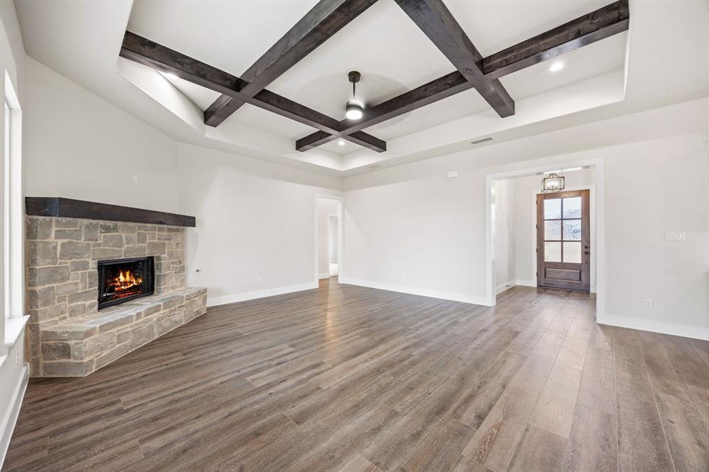 13835 Cashs Mill Road Sanger, TX 76266 - Photo 3 of 32 a view of an empty room with wooden floor a fireplace and a window