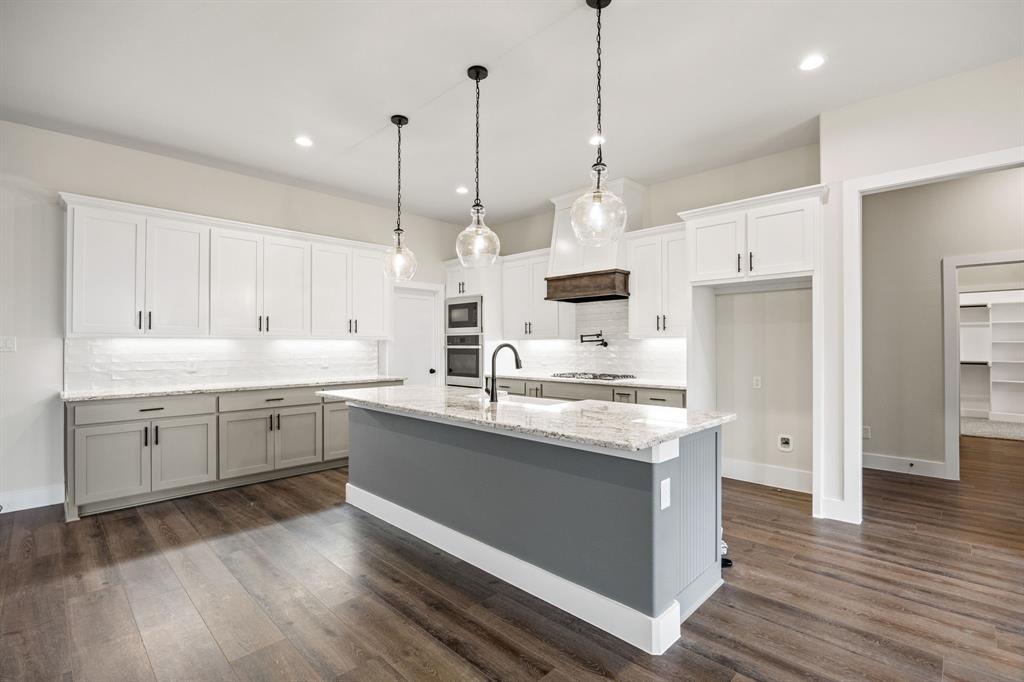 13835 Cashs Mill Road Sanger, TX 76266 - Photo 10 of 32 a kitchen with stainless steel appliances granite countertop a sink a stove a refrigerator and white cabinets with wooden floor