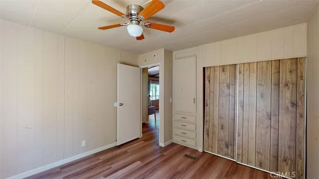a view of a hallway with wooden floor and furniture