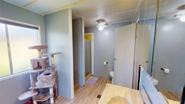 an empty room with windows and fan