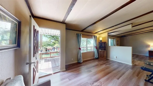 a view of a hallway with wooden floor and furniture