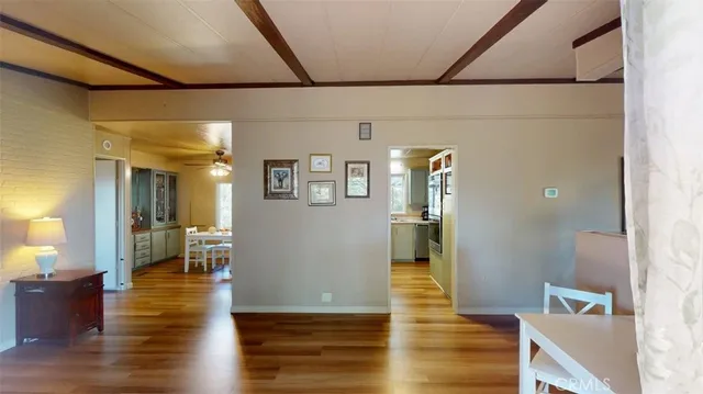 a kitchen with stainless steel appliances kitchen island granite countertop a refrigerator a stove and a dining table with wooden floor