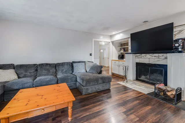 a living room with furniture a flat screen tv and a fireplace