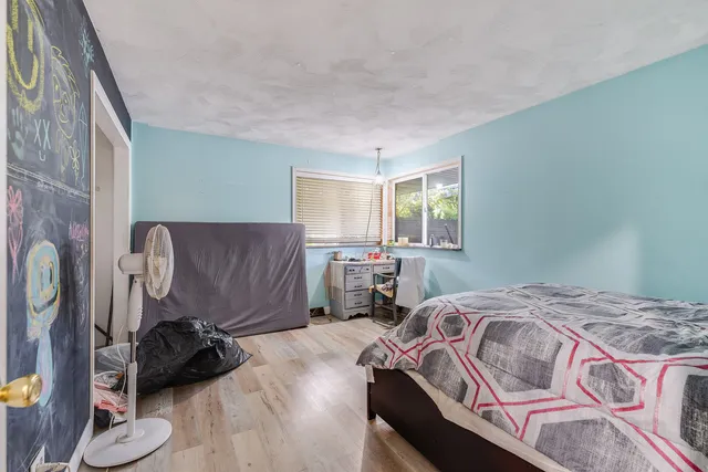 a bedroom with a bed and wooden floor