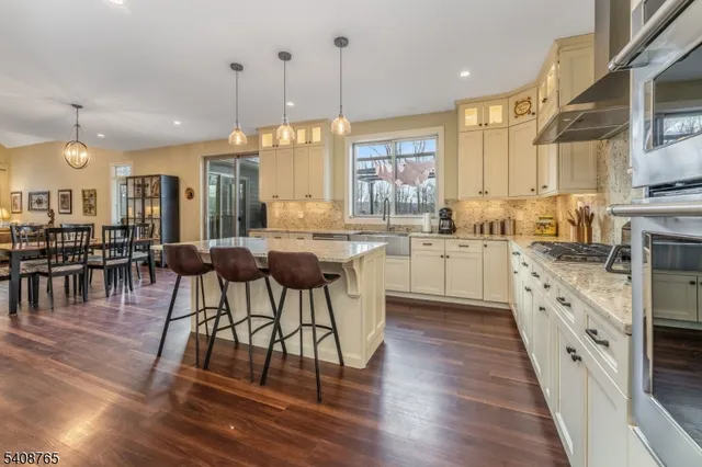 a kitchen with stainless steel appliances granite countertop wooden floors stove sink and cabinets