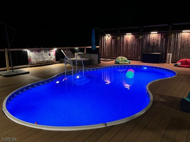 a view of a wooden deck with swimming pool and patio