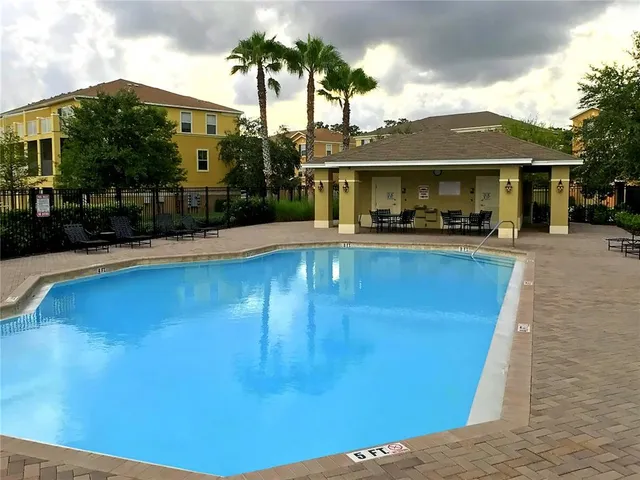 a view of a house with pool and sitting area