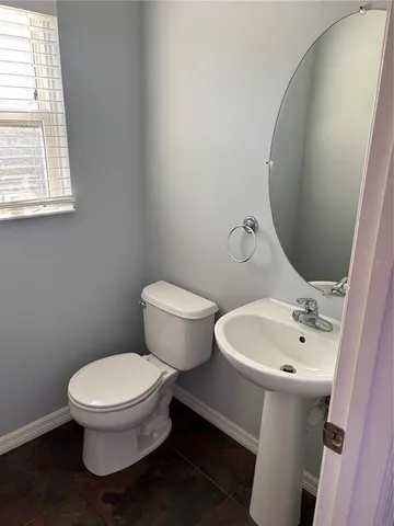 a white toilet sitting next to a bathroom sink