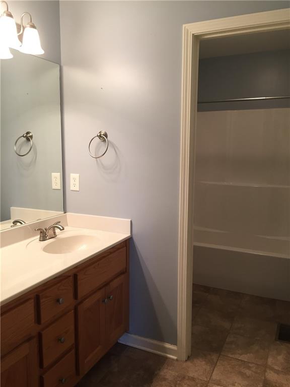 10 Sarah Street Northwest Rome, GA 30165 - Photo 11 of 14 a bathroom with a granite countertop sink a mirror and a bathtub
