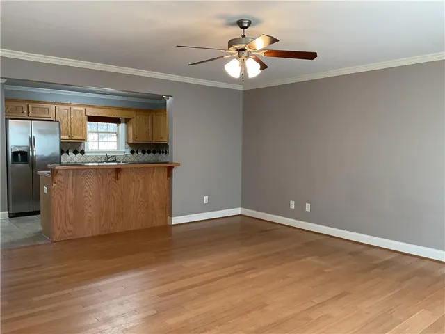 a view of a kitchen with wooden floor and a ceiling fan