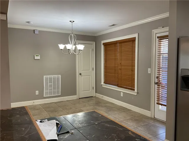 a view of a livingroom with a chandelier fan and windows