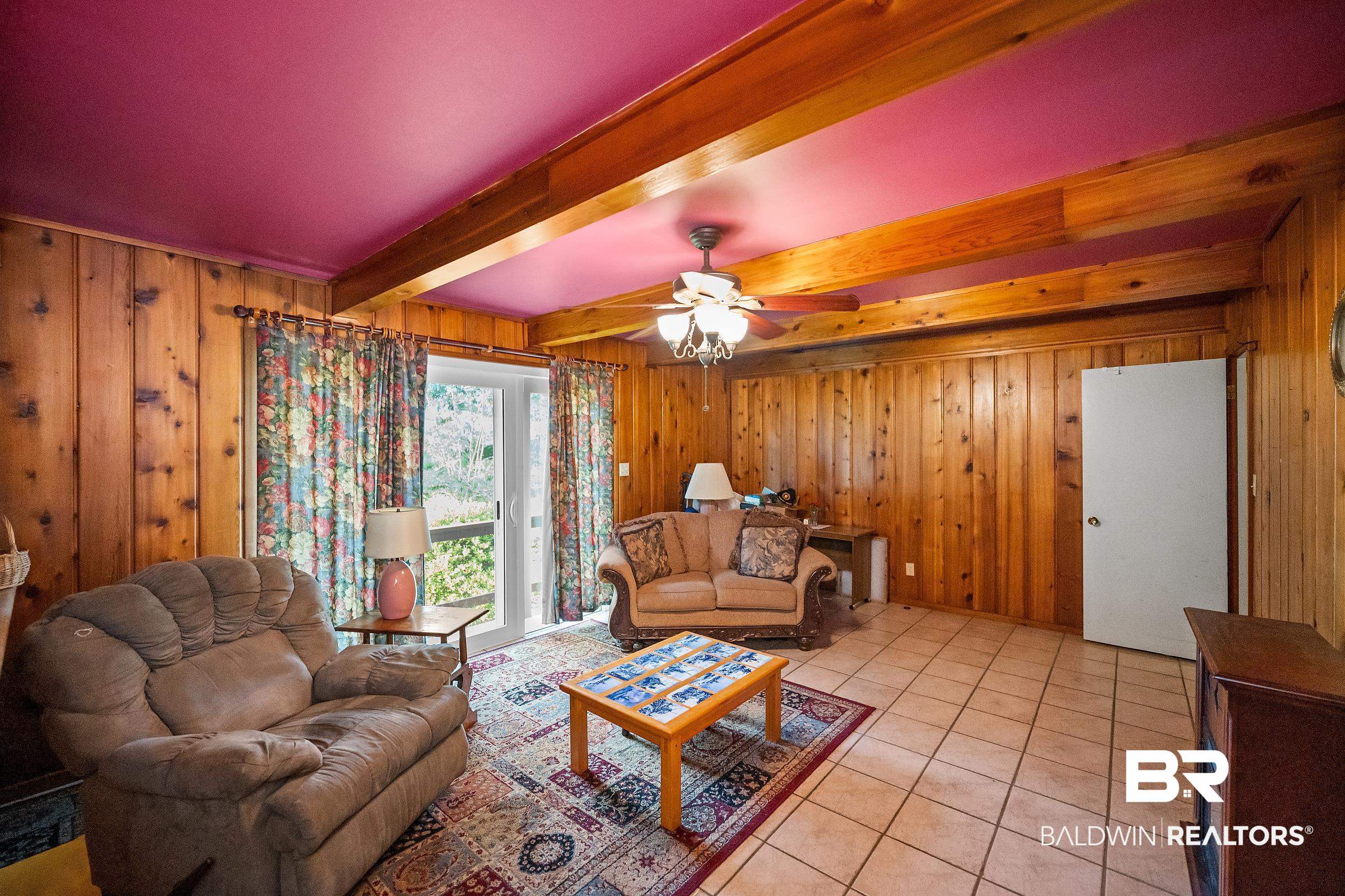 135 Pineridge Road Daphne, AL 36526 - Photo 8 of 19 Wood-paneled living area featuring exposed wood beams, a magenta ceiling, and light-toned tile flooring