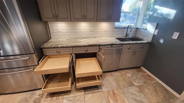 a kitchen with kitchen island a counter space a sink appliances and cabinets
