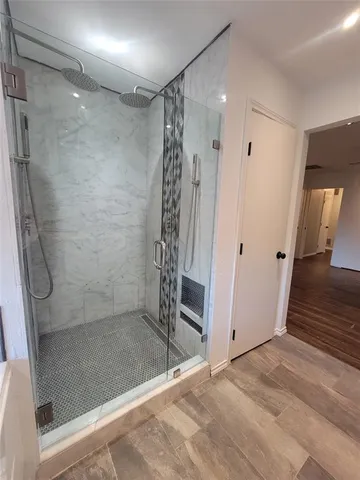 a bathroom with a shower and a glass door