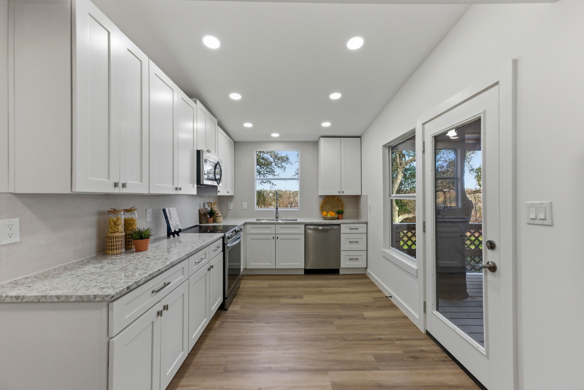 2649 Crazyhorse Pass Austin, TX 78734 - Photo 11 of 40 Kitchen with recessed lighting, white cabinets, light stone countertops, light wood-style floors, and stainless steel appliances