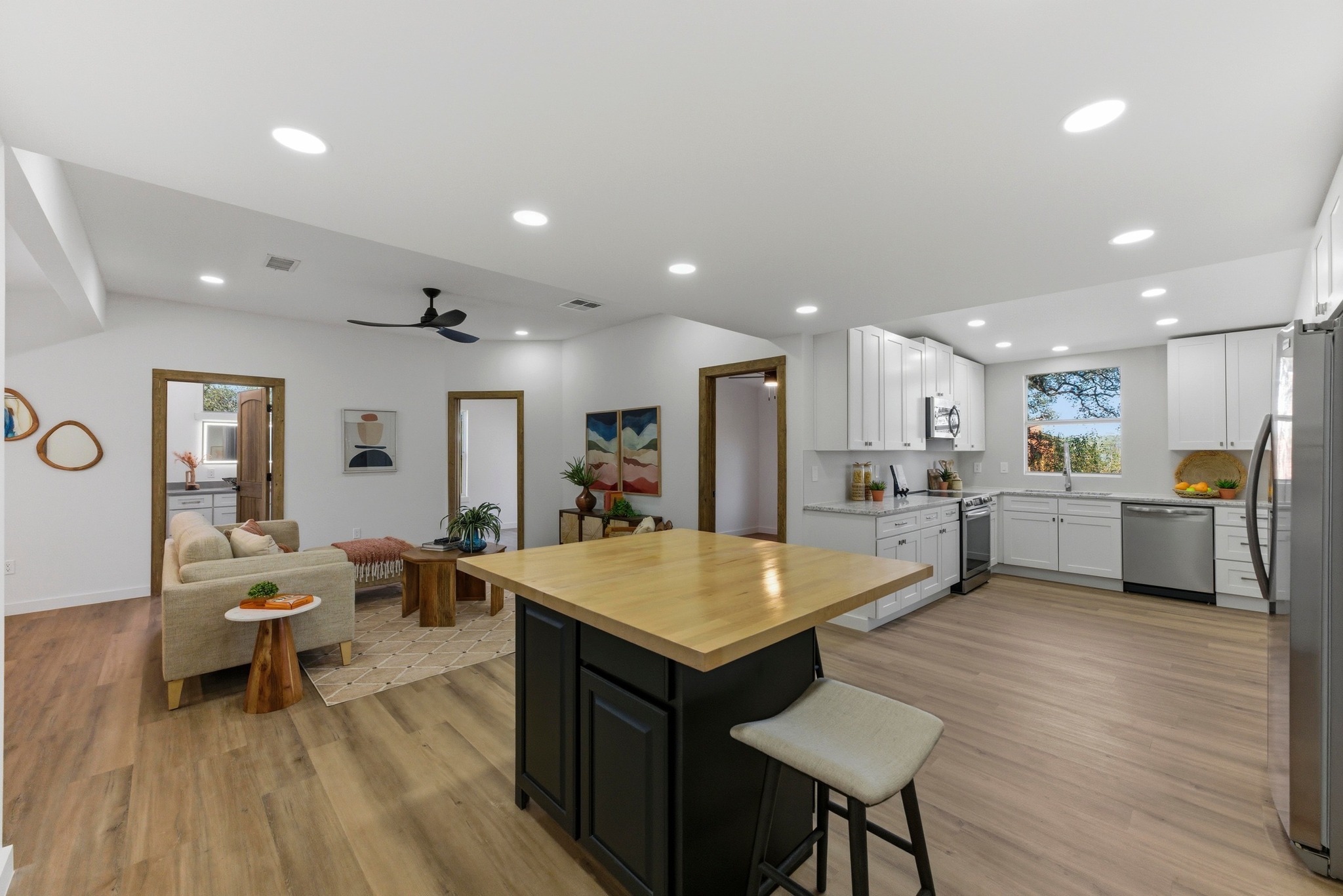 2649 Crazyhorse Pass Austin, TX 78734 - Photo 39 of 40 Dual tone kitchen with butcher block counters, stainless steel appliances, a kitchen bar, open floor plan, and a kitchen island