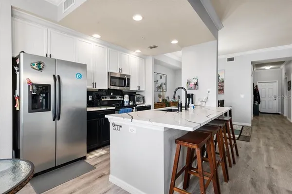 a kitchen with stainless steel appliances a stove a sink a microwave and cabinets