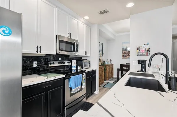 a kitchen with counter top space cabinets stainless steel appliances and wooden floor