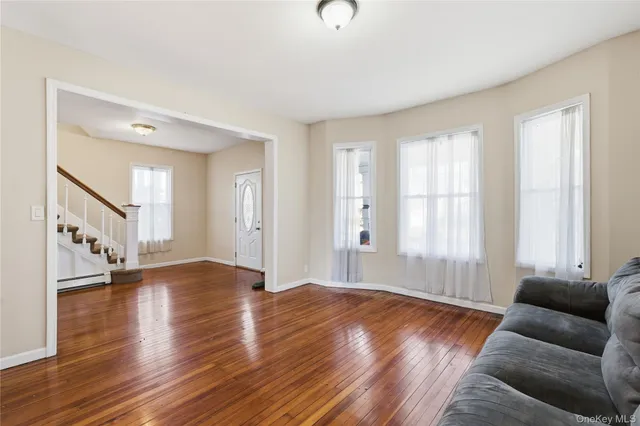 a view of a livingroom with a fireplace a ceiling fan and windows