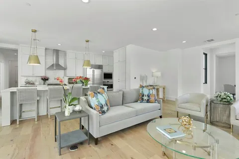 a living room with furniture kitchen view and a dining table