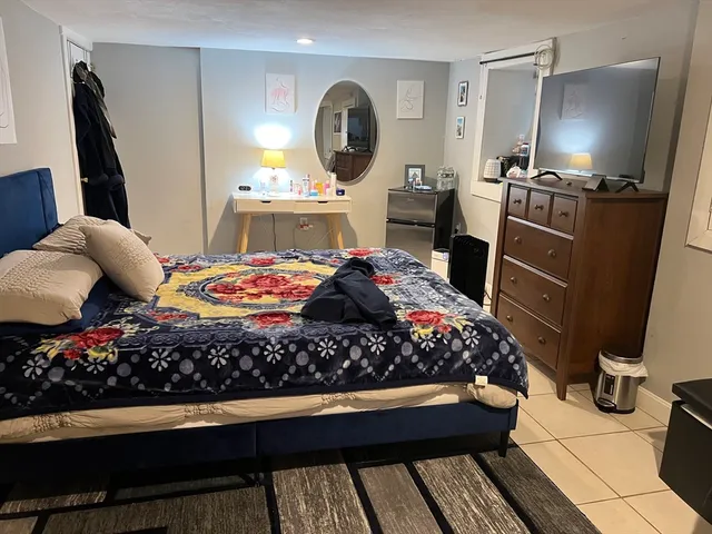 a bed room with a bed television and a flat screen tv