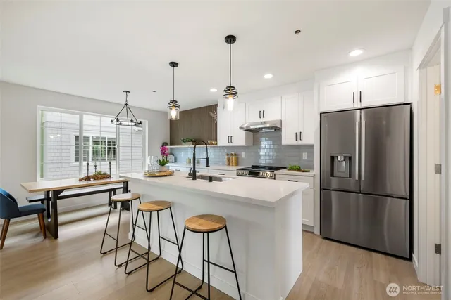 a kitchen with refrigerator a table and chairs
