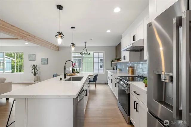 a kitchen with stainless steel appliances granite countertop a sink stove and refrigerator