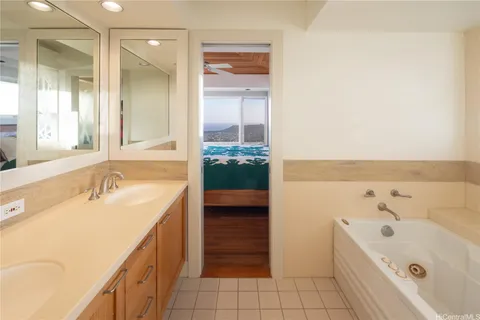 a bathroom with a tub sink and mirror