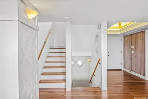 a view of a hallway with wooden floor and staircase