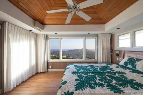 a bedroom with a bed and a large window with balcony view