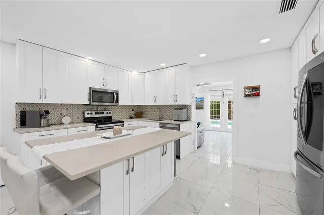 a kitchen with stainless steel appliances a stove refrigerator sink and cabinets