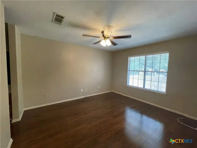 a view of empty room with wooden floor