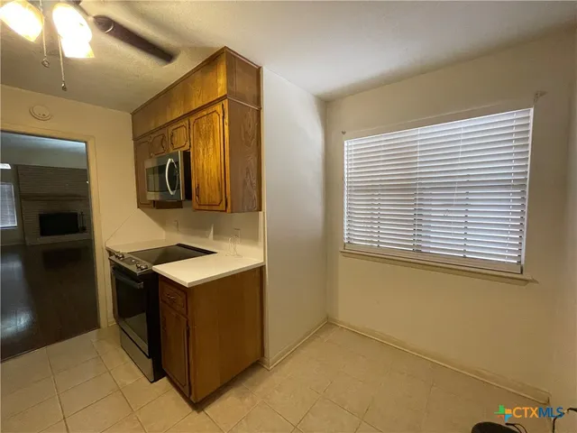 a kitchen with stainless steel appliances granite countertop a sink and a refrigerator