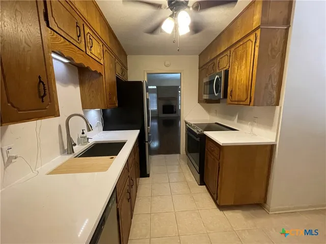 a kitchen with stainless steel appliances a stove a microwave and a sink