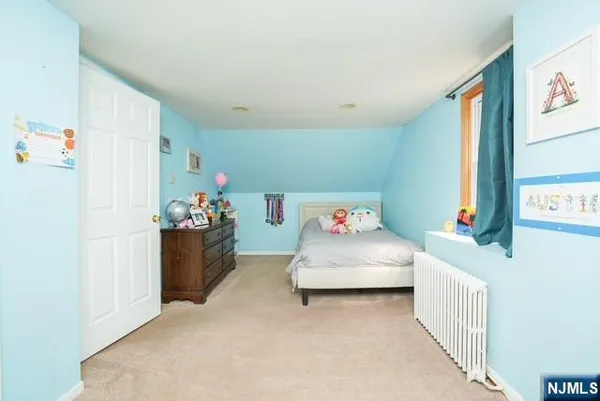 a bedroom with a bed and a refrigerator