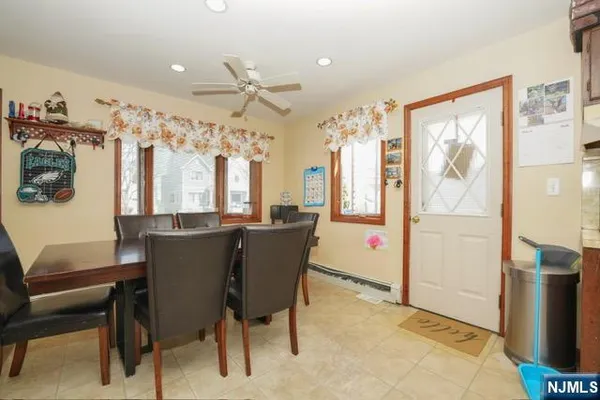 a view of a dining room with furniture a chandelier and a window