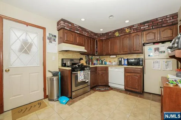 a kitchen with granite countertop a refrigerator stove top oven and sink