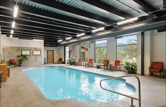 a swimming pool with outdoor seating and a potted plant