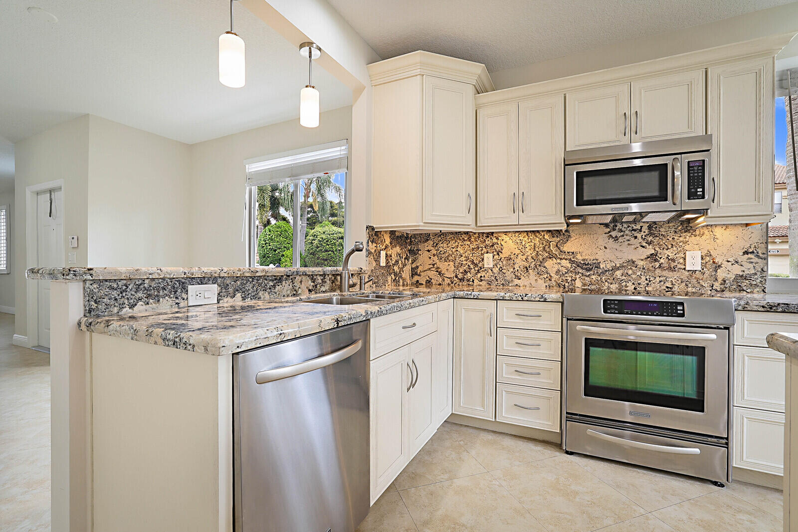 6819 Via Regina Boca Raton, FL 33433 - Photo 14 of 39 a kitchen with stainless steel appliances granite countertop a stove a sink and a microwave
