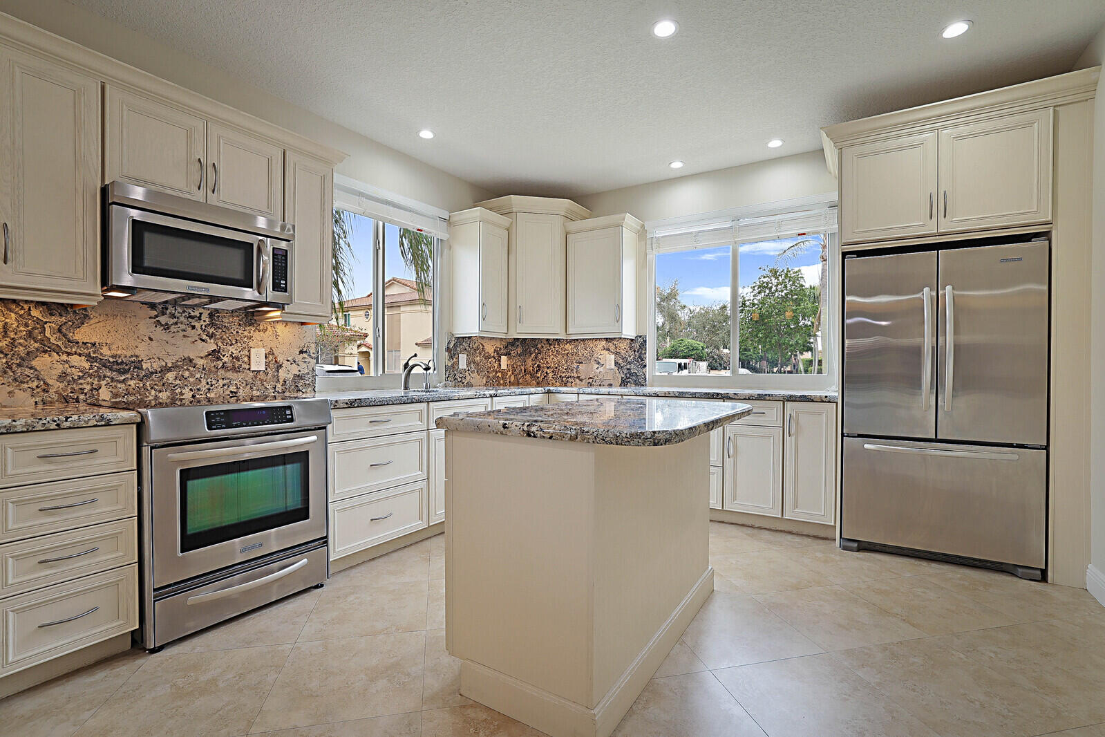 6819 Via Regina Boca Raton, FL 33433 - Photo 17 of 39 a kitchen with stainless steel appliances granite countertop a refrigerator sink stove microwave and cabinets
